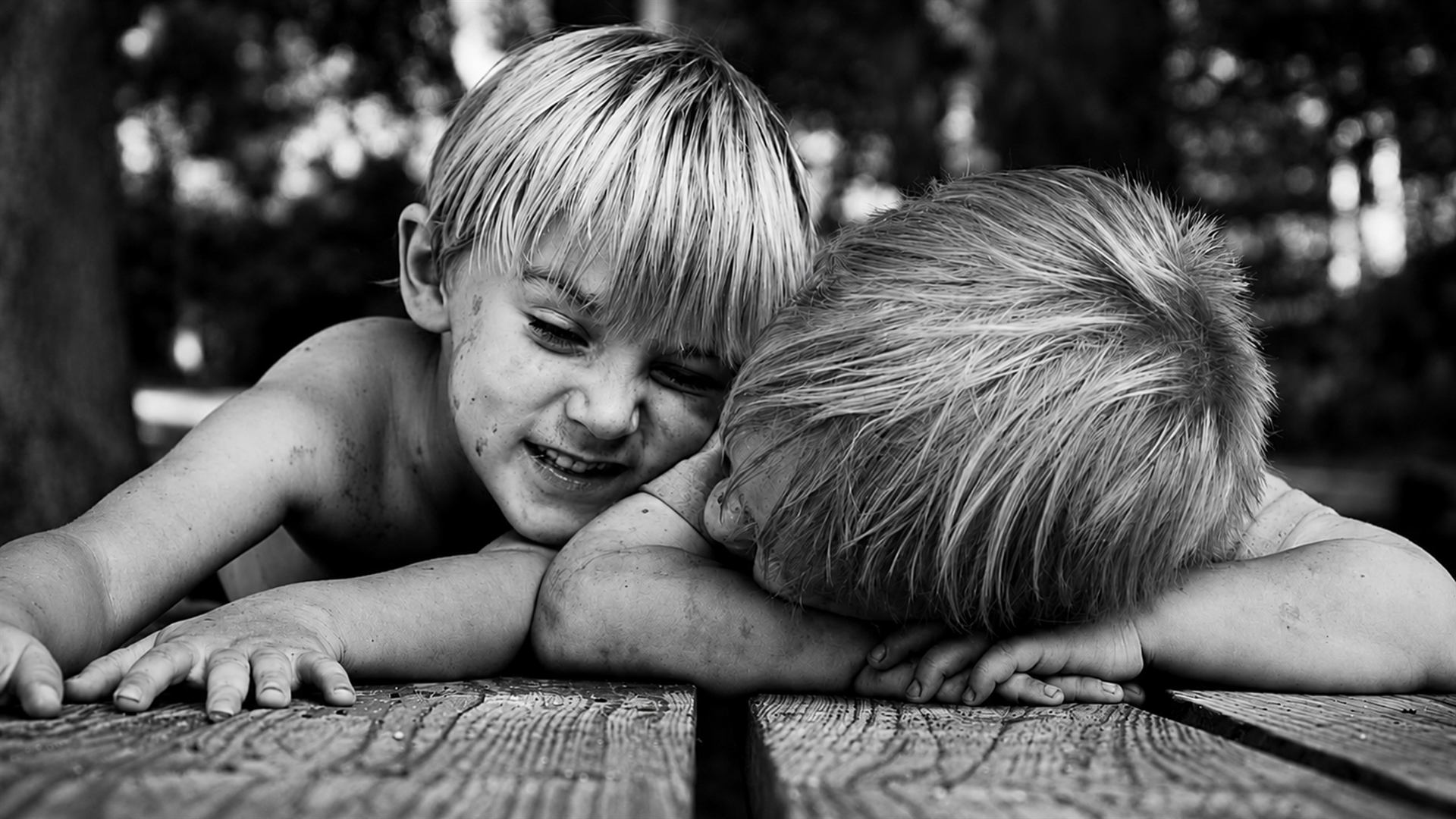 Black and white portrait of two children on a wooden deck