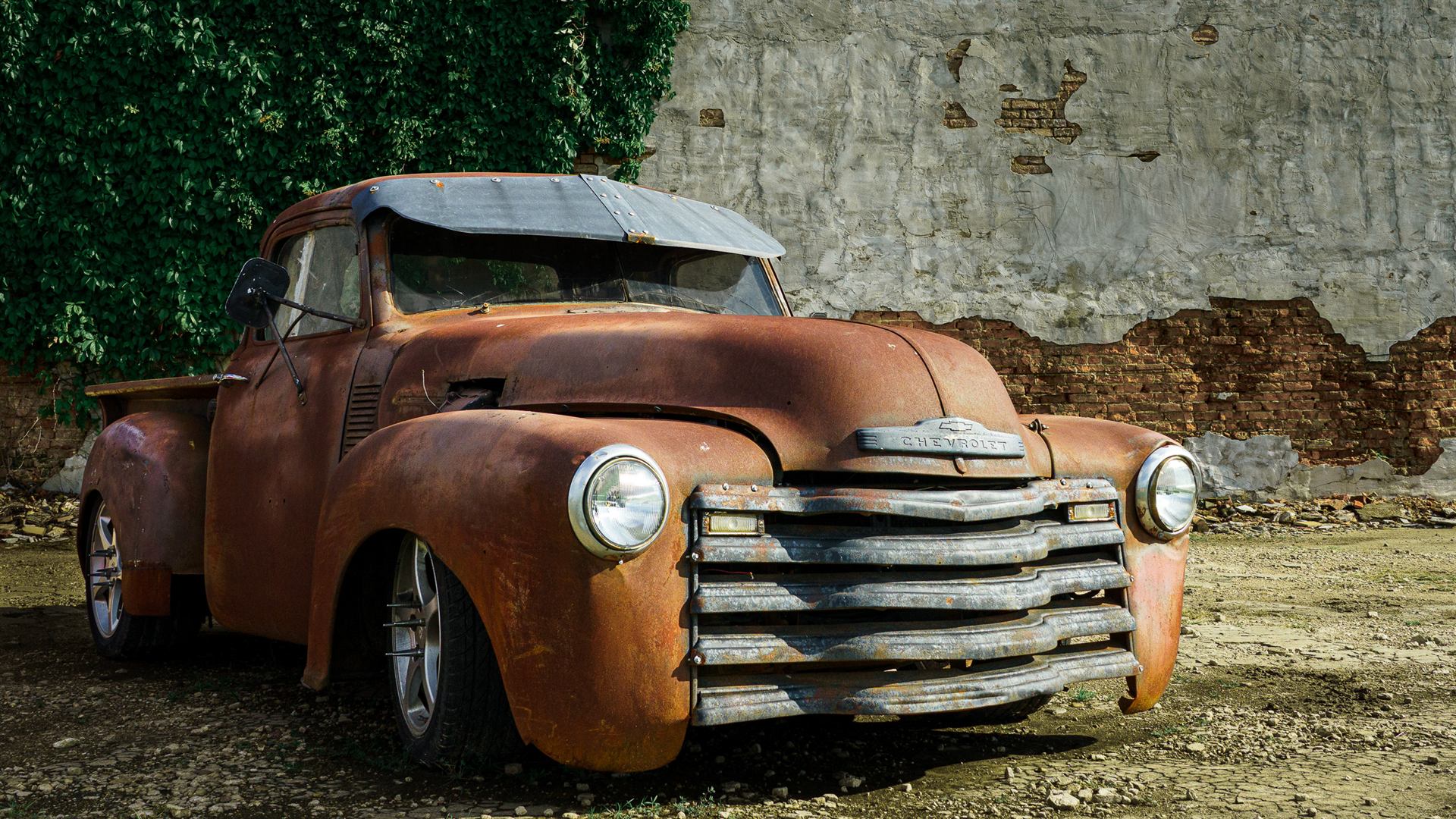 Rustic Chevrolet truck photographed against an old brick wall