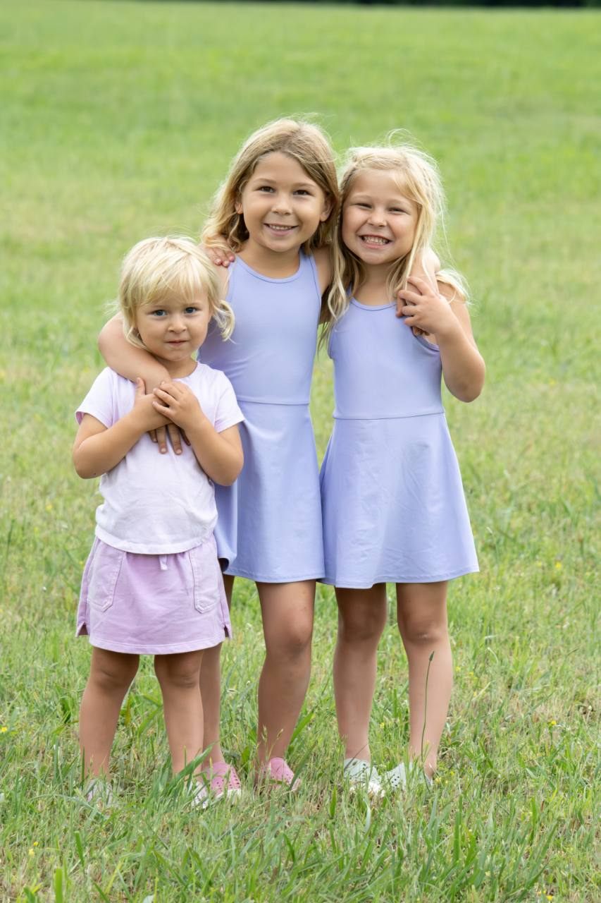 Portrait of three young girls standing together in a field