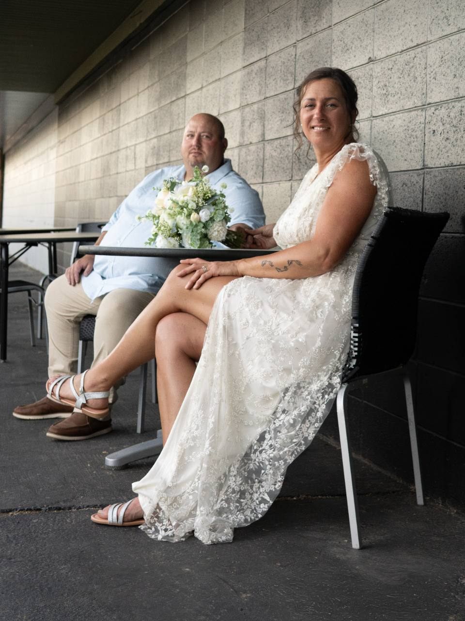 Wedding couple seated together with bouquet