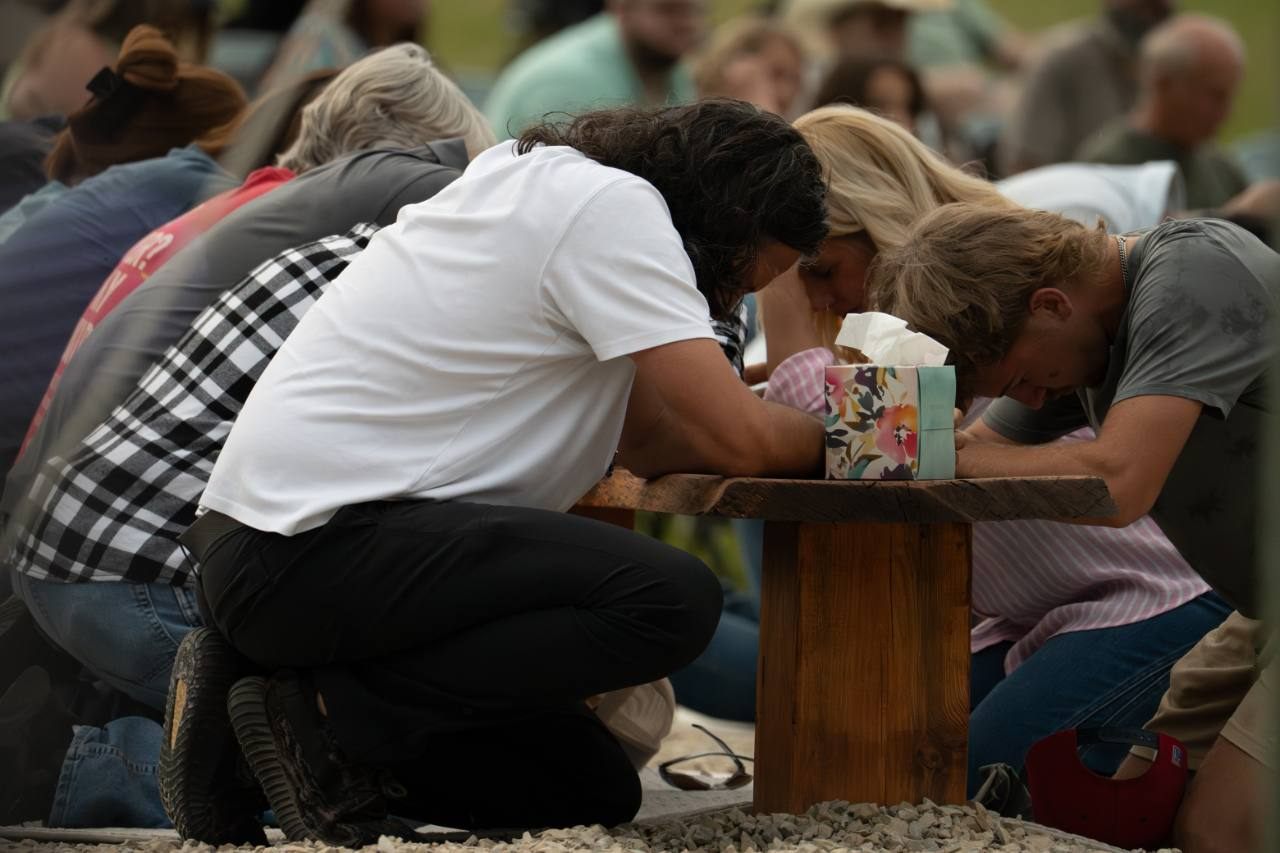 Outdoor candid photograph of people gathered in prayer