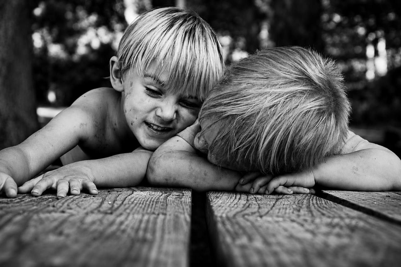 Black and white photo of two boys on a wooden deck