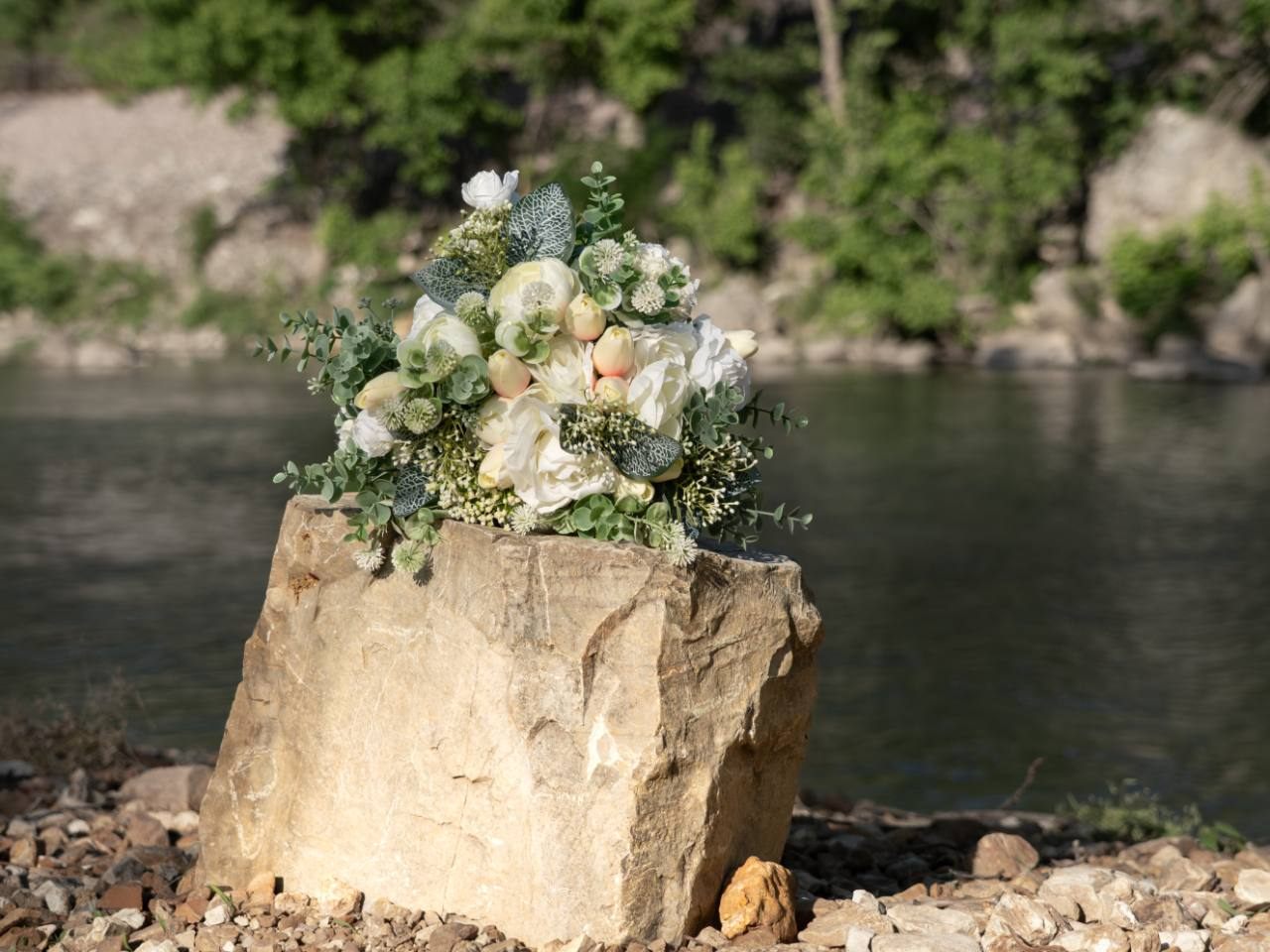 Wedding bouquet on a rock near the river